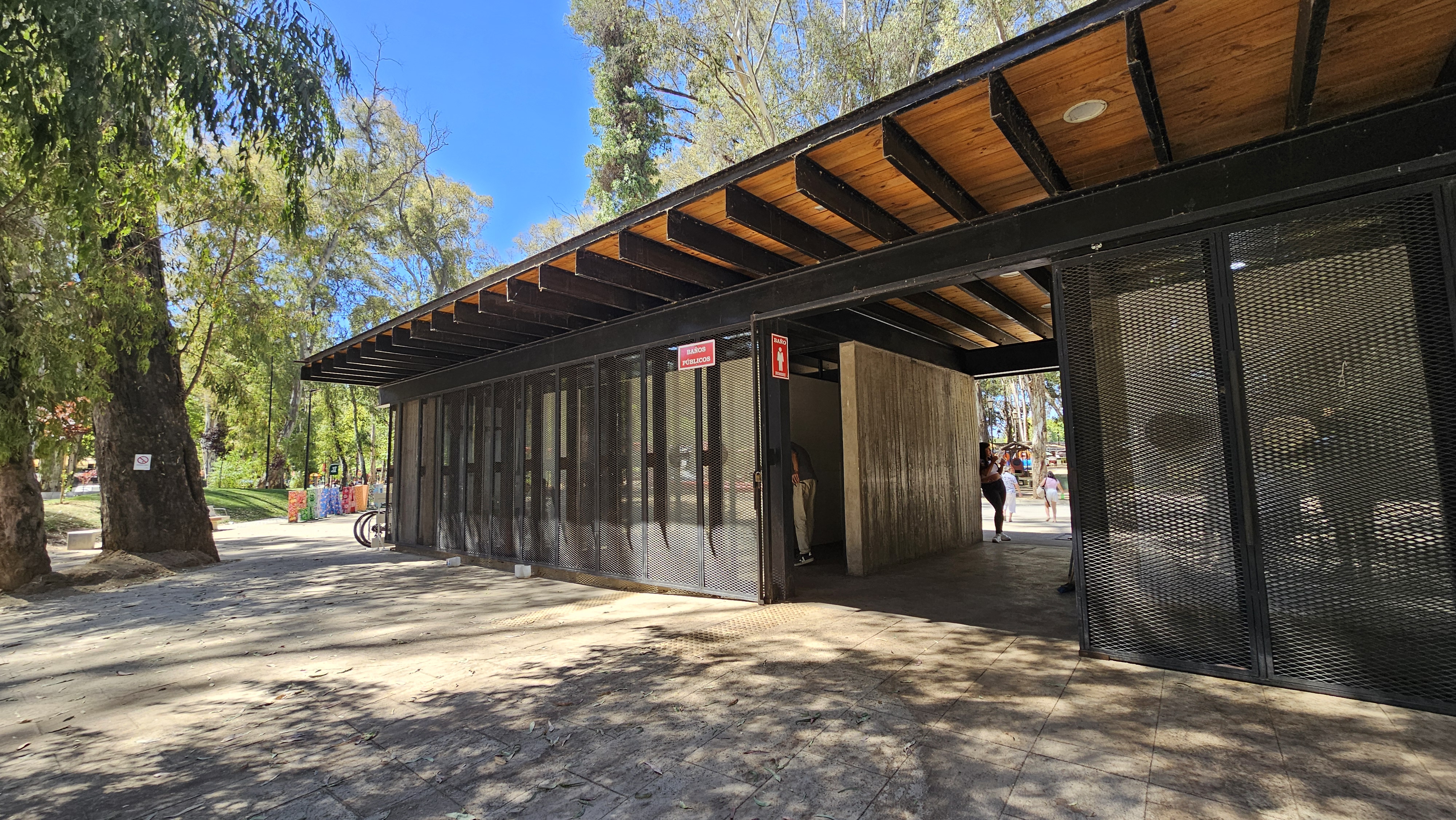 Fotografía del exterior de los baños, donde se aprecia la construcción con gran espacio y un pasillo techado
